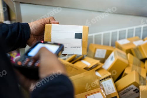 Preview: Delivery man using laser scanner scanning parcel cardboard box in distribution center