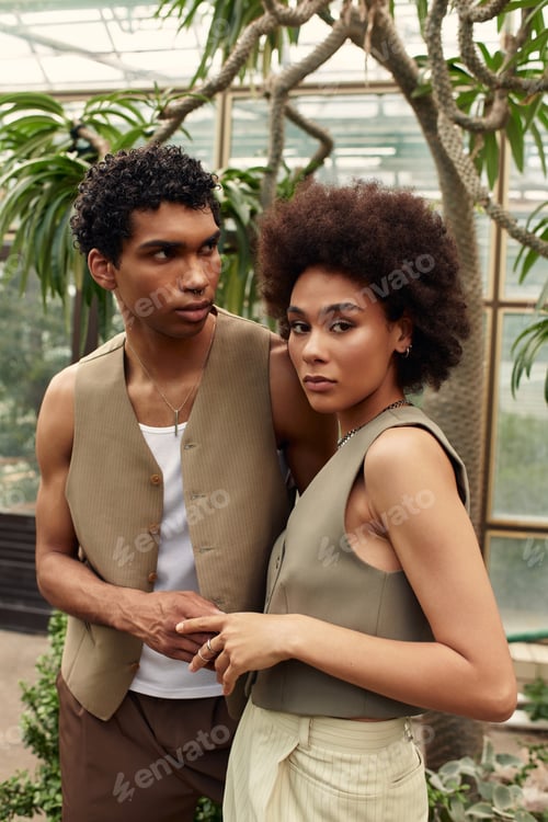 Preview: Young couple shares a moment of love amidst vibrant greenery in a beautiful greenhouse setting