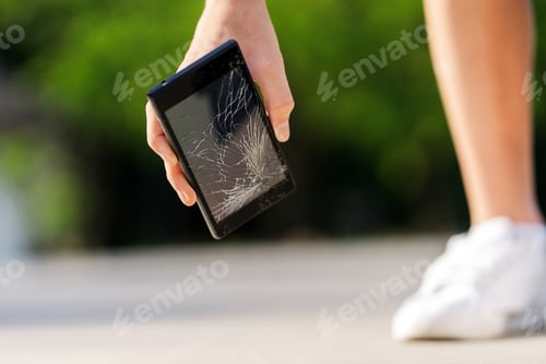 Preview: Cropped view of the kid boy with broken mobile phone at skatepark