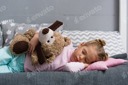 Preview: adorable little kid sleeping on couch with teddy bear