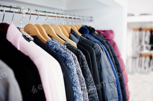 Preview: Close-up photo of fashionable clothes on hangers in the shop.