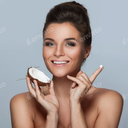 Preview: Beautiful young woman with a coconut and moisturizing cream