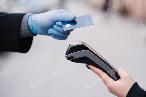 Preview: Faceless human in medical gloves during coronavirus epidemic, holds plastic card