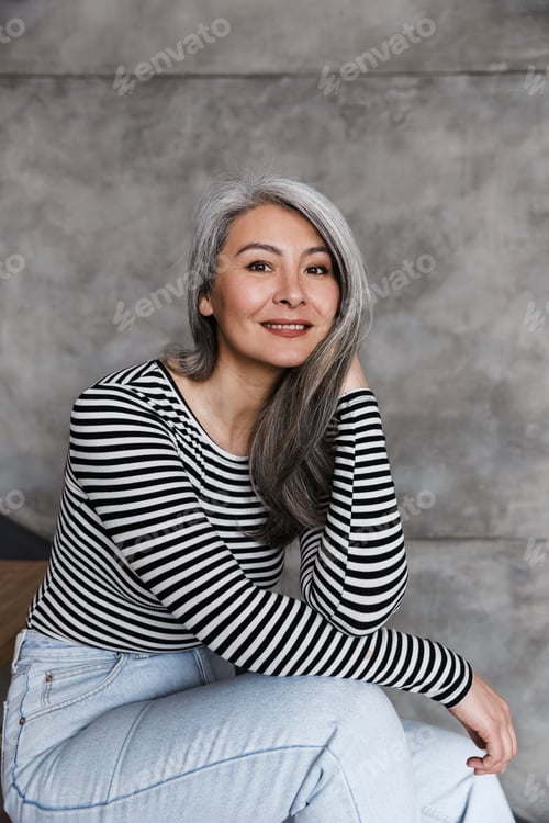 Preview: Photo of happy adult asian woman smiling and looking at camera