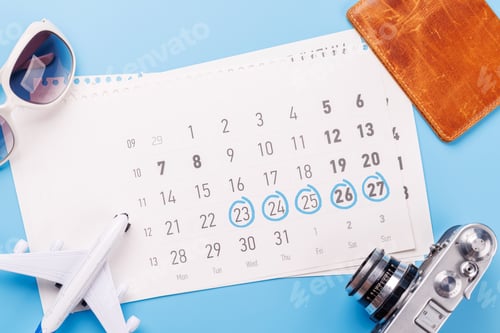 Preview: Travel-themed flat lay with calendar, toy airplane, camera, and sunglasses