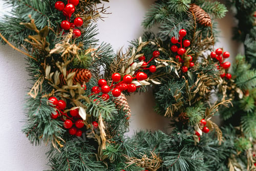 Preview: Evergreen wreath with red berries and pine cones decoration detail close up