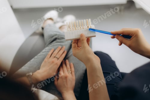 Preview: Smile and white teeth of a young woman. Matching the shades of the implants or the process