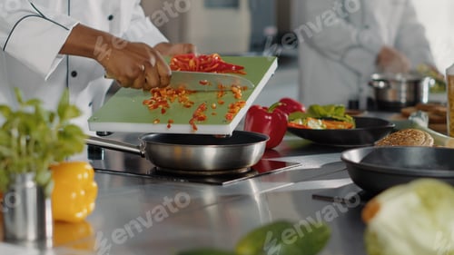 Preview: Male chef preparing chopped bell pepper in restaurant kitchen