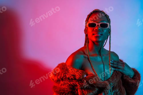 Preview: Attractive black woman with braids with red and blue led lights, studio shoot