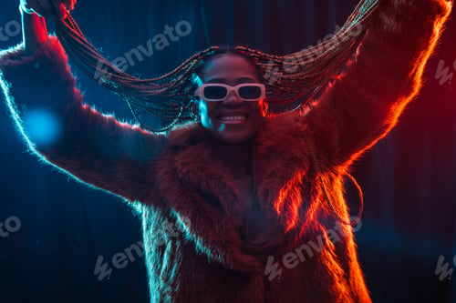 Preview: Black ethnic woman with braids with blue and red led lights, moving her hair while dancing