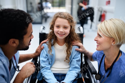 Preview: Young multiracial doctor with his colleague talking with little girl on wheelchair.