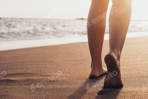 Preview: Beach travel - woman walking on sand beach leaving footprints in the sand.
