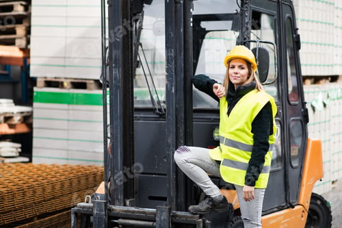 Preview: Woman forklift truck driver in an industrial area.