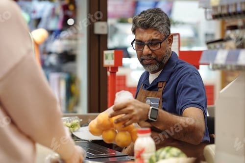 Preview: Indian Man as Cashier in Store