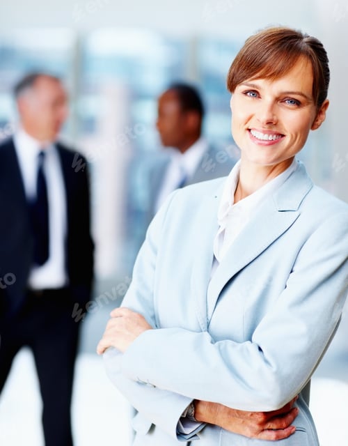 Preview: Female executive standing casually with colleagues in background