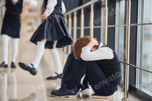 Preview: Boy in uniform sitting alone with feeling sad at school. Conception of harassment