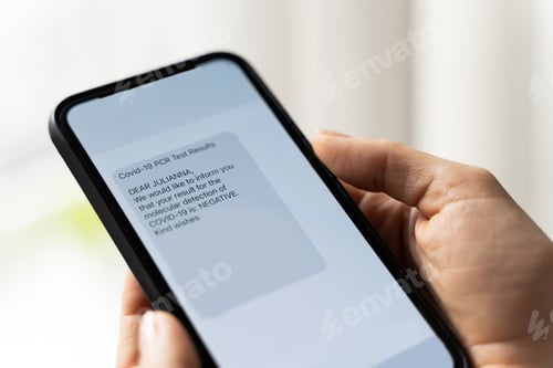 Preview: Hands and smartphone with a message showing negative result of PCR test of COVID-19.