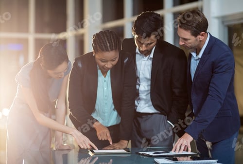 Preview: Group of businesspeople discussing together over digital tablet