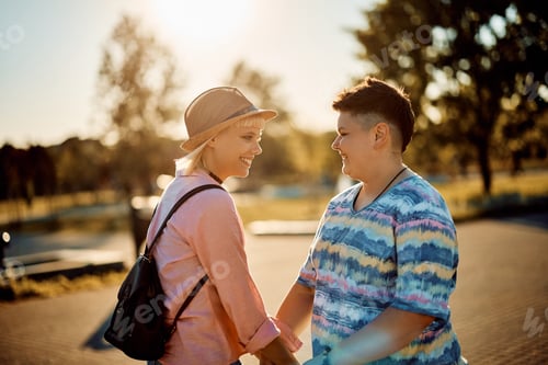 Preview: Young happy lesbian couple enjoying in their time together in nature at sunset.