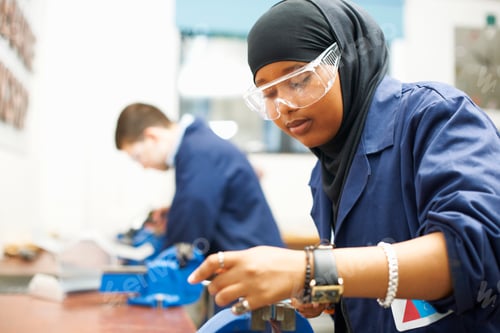 Preview: Female student using vice grip in college workshop