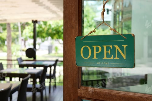 Preview: A welcoming 'OPEN' sign hanging at the entrance of a cozy cafe.