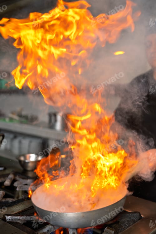 Preview: Chef cooking peruvian food with fire in a restaurant kitchen