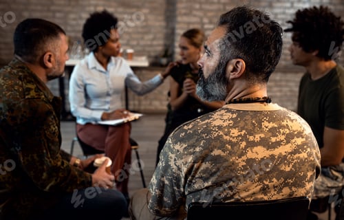Preview: Group of diverse veterans talking during PTSD support group.