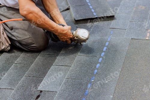 Preview: New asphalt bitumen shingles are being installed by roofer using a pneumatic air nail gun