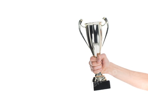 Preview: Close up view of silver trophy in hand of sportsman isolated on white