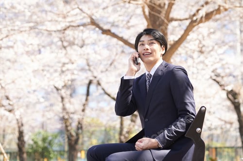 Preview: A Japanese male businessman calls with a smile on his face.