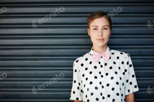 Preview: Portrait of a trendy young woman standing against a corrugated background