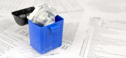 Preview: Many american tax blank forms and crumpled hundred dollar bill in trash bin