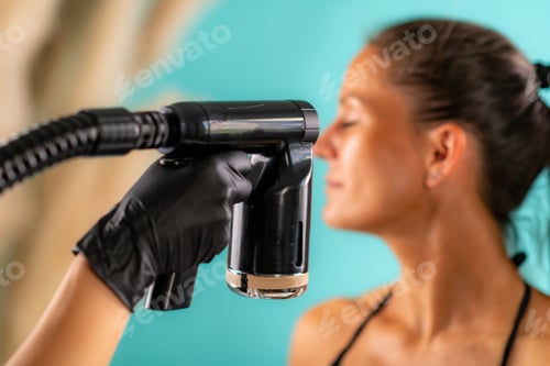 Preview: Woman gently drying her face with a fan after a facial spray tan session