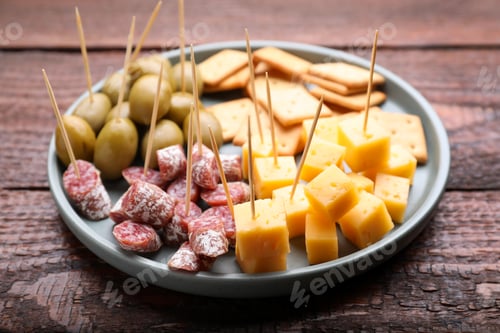 Preview: Toothpick appetizers. Pieces of cheese, sausage and olives on wooden table