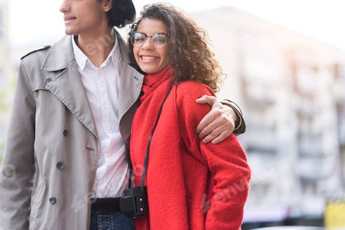 Preview: Cute Loving Couple Is Embracing While Standing On Street. Happy Woman Is Looking At Camera And