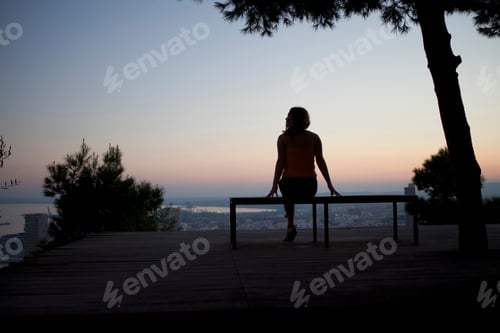 Preview: Woman admiring view from park bench