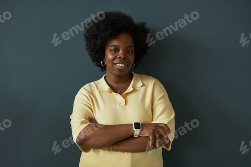 Preview: Portrait of Young Adult Black Woman Smiling with Arms Crossed Indoors