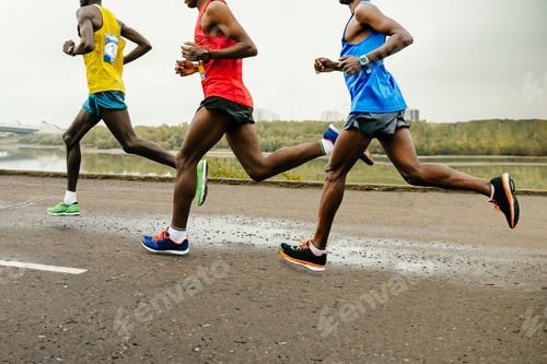 Preview: leading group african runners dressed in bright sports clothes race along calm river,