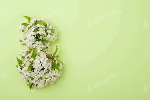 Preview: 8 March greeting card. Paper cut Eight made of green background and fresh spring flowers bouquet of