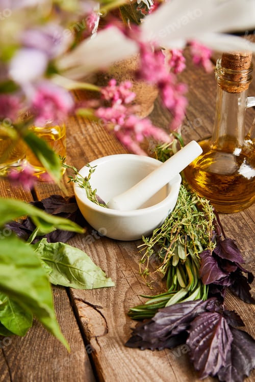 Preview: mortar with pestle near bottle and fresh leaves and flowers on wooden surface
