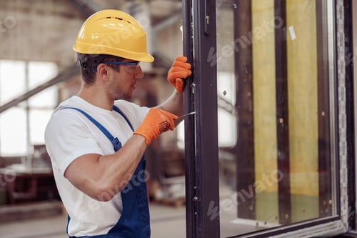 Preview: Male worker fixing door in building under construction
