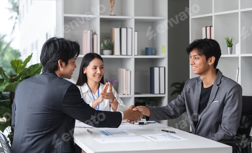 Preview: Successful Businessmen Shaking Hands and Signing a Contract in a Modern Office Setting