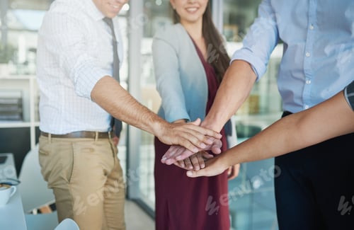 Preview: Shot of a group of colleagues joining their hands together in solidarity