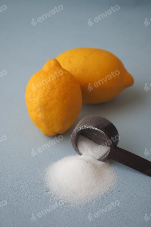 Preview: Coarse salt in a spoon and lemon on black background
