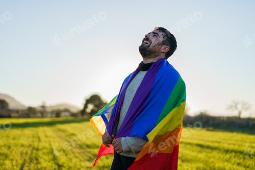 Preview: Man laughing in field LGBT flag