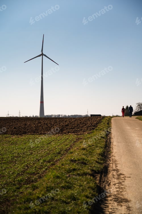 Preview: Vertical shot of a road leading to the windmill on the land