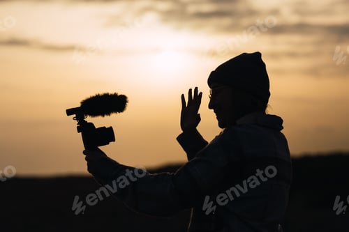Preview: Anonymous happy lady recording vlog on camera under sundown sky