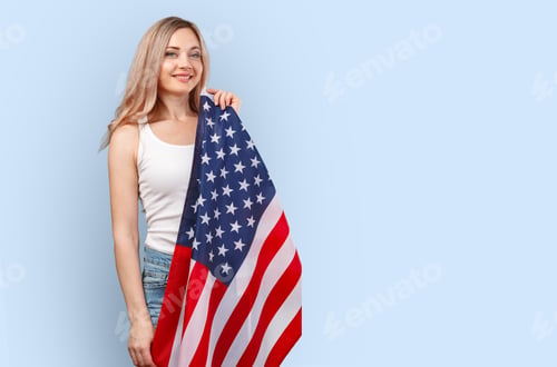 Preview: Portrait of a young woman holding USA flag isolated on color background