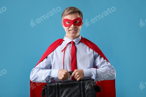 Preview: Businessman wearing superhero costume on light blue background