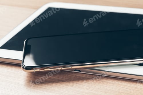 Preview: Digital tablet and mobile phone. Electronic devices on wooden table, close up.